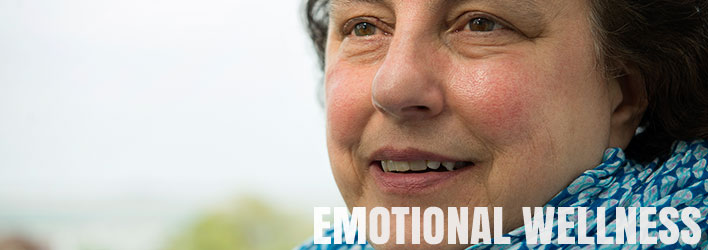 Photo of smiling woman with words EMOTIONAL WELLNESS underneath.