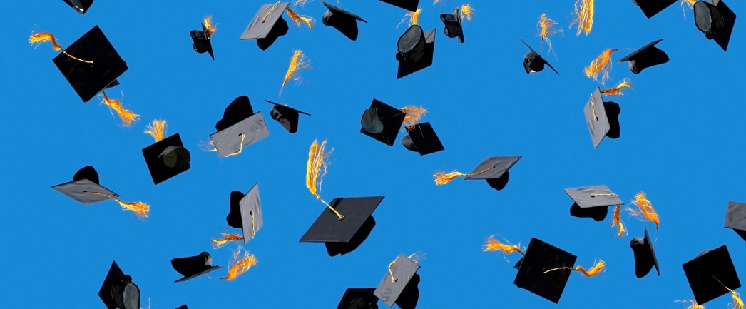 graduation caps thrown into the air