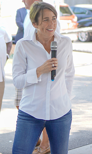 AG Healey standing and holding a microphone