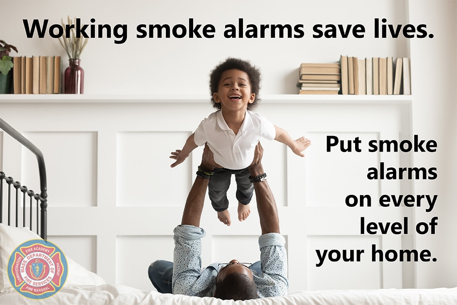 Father and son playing with the text, "Smoke alarms save lives."
