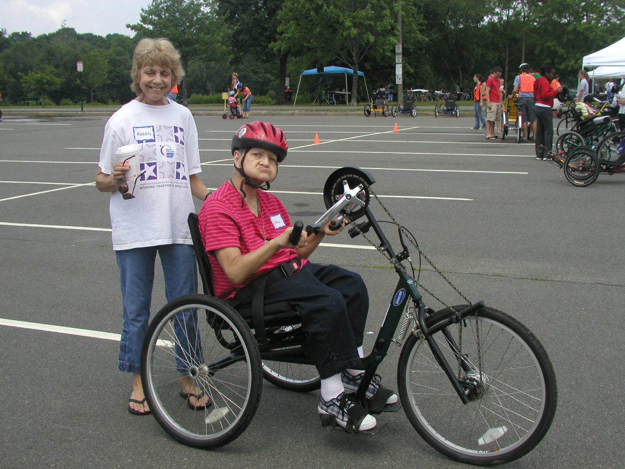 Person sitting on Invacare Bike next to person standing and smiling at the camera