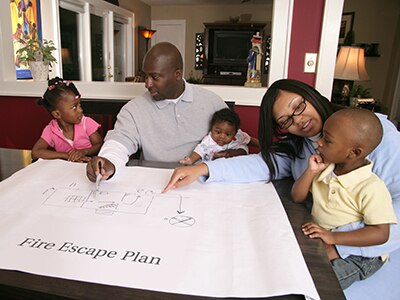 Family making a home escape plan on paper. 