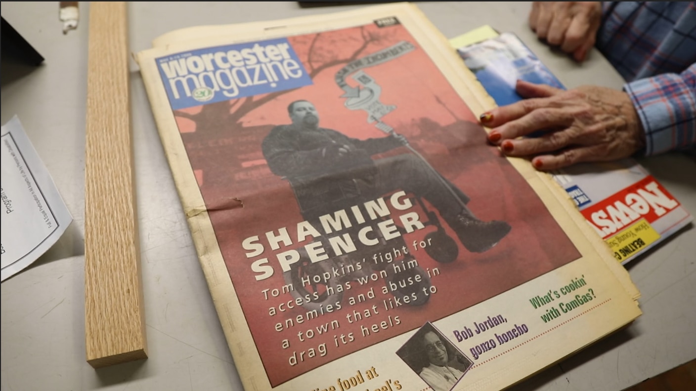 The cover of Worcester Magazine, with a black and white photo of Tom in his wheelchair, with the words "Shaming Spencer: Tom Hopkins' fight for access has won him enemies and abuse in a town that likes to drag its heels."