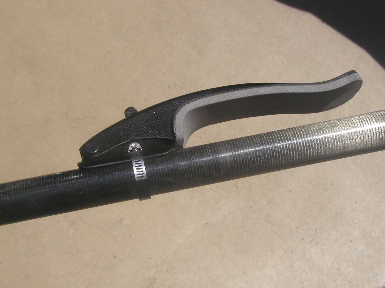 A closeup of a hand grip mounted on a paddle. The grip is closed at one and and open at the other.