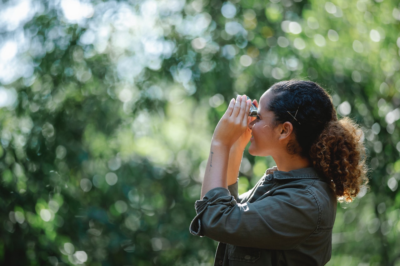 woman looks through binoculars