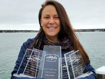 An angler holding up her derby awards.