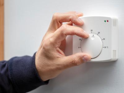 Person adjusts a thermostat