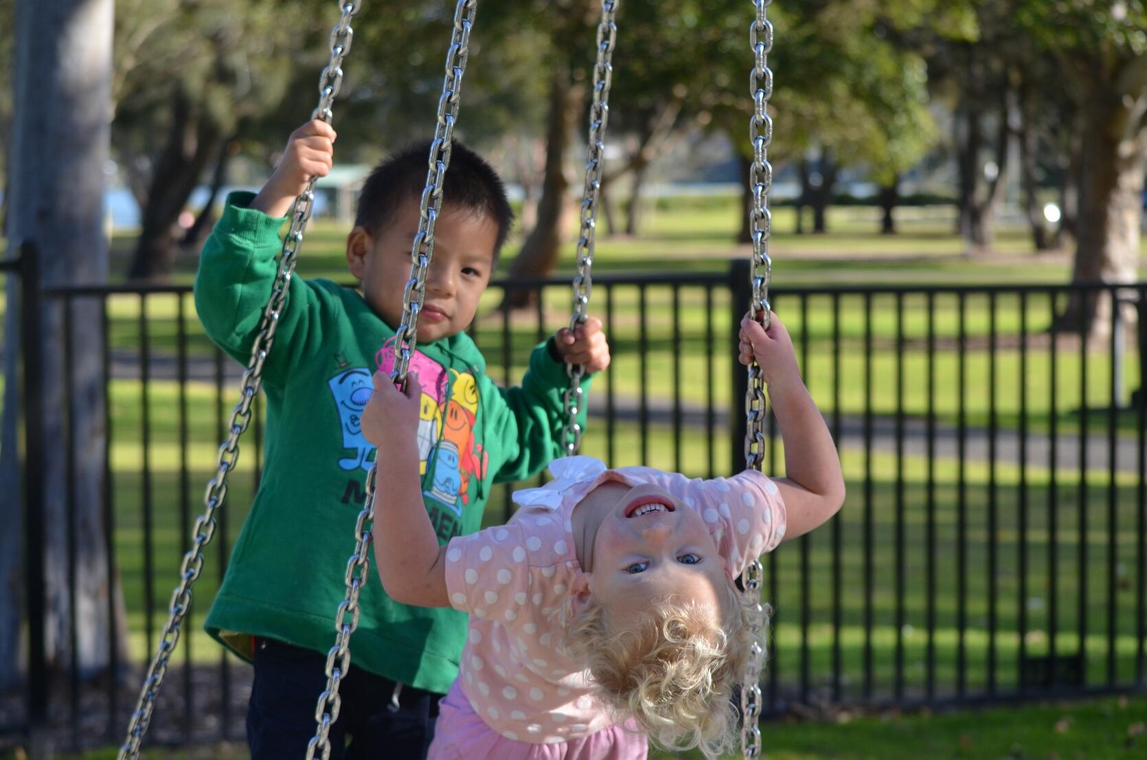 Children playing on a tire swing.