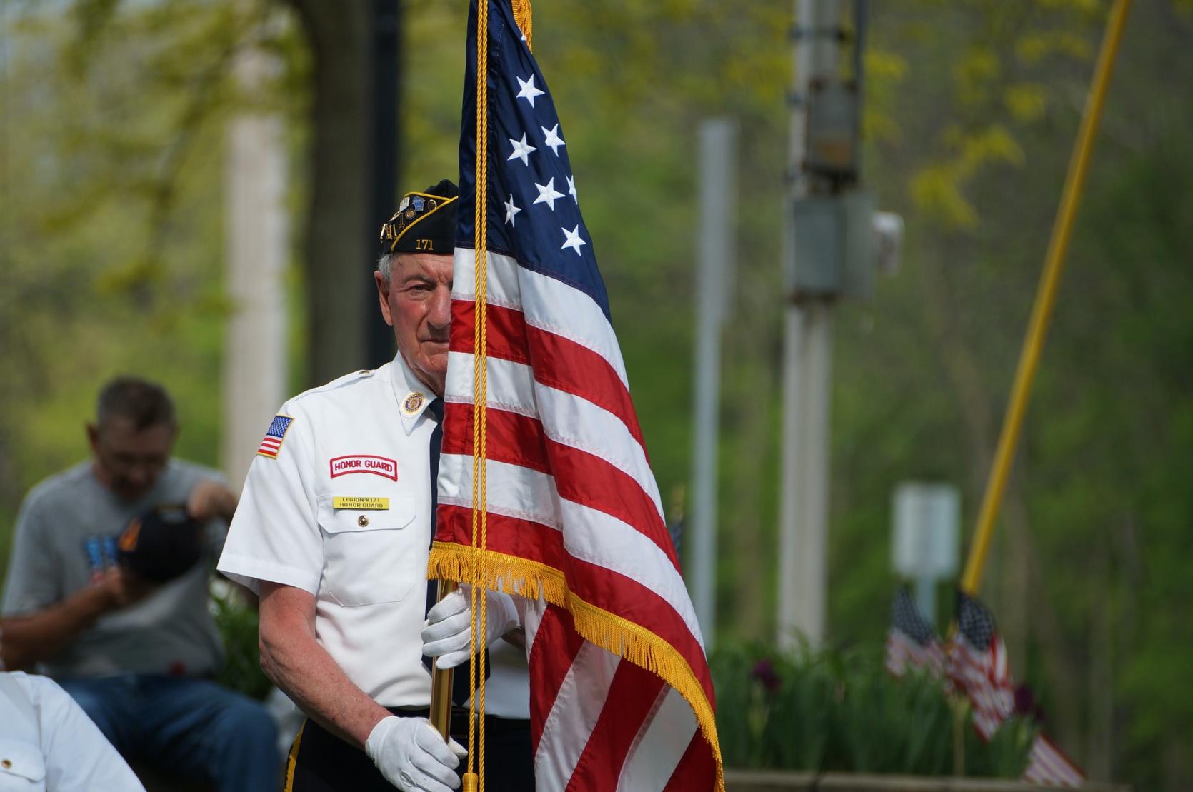 A veteran carrying the United States flag.