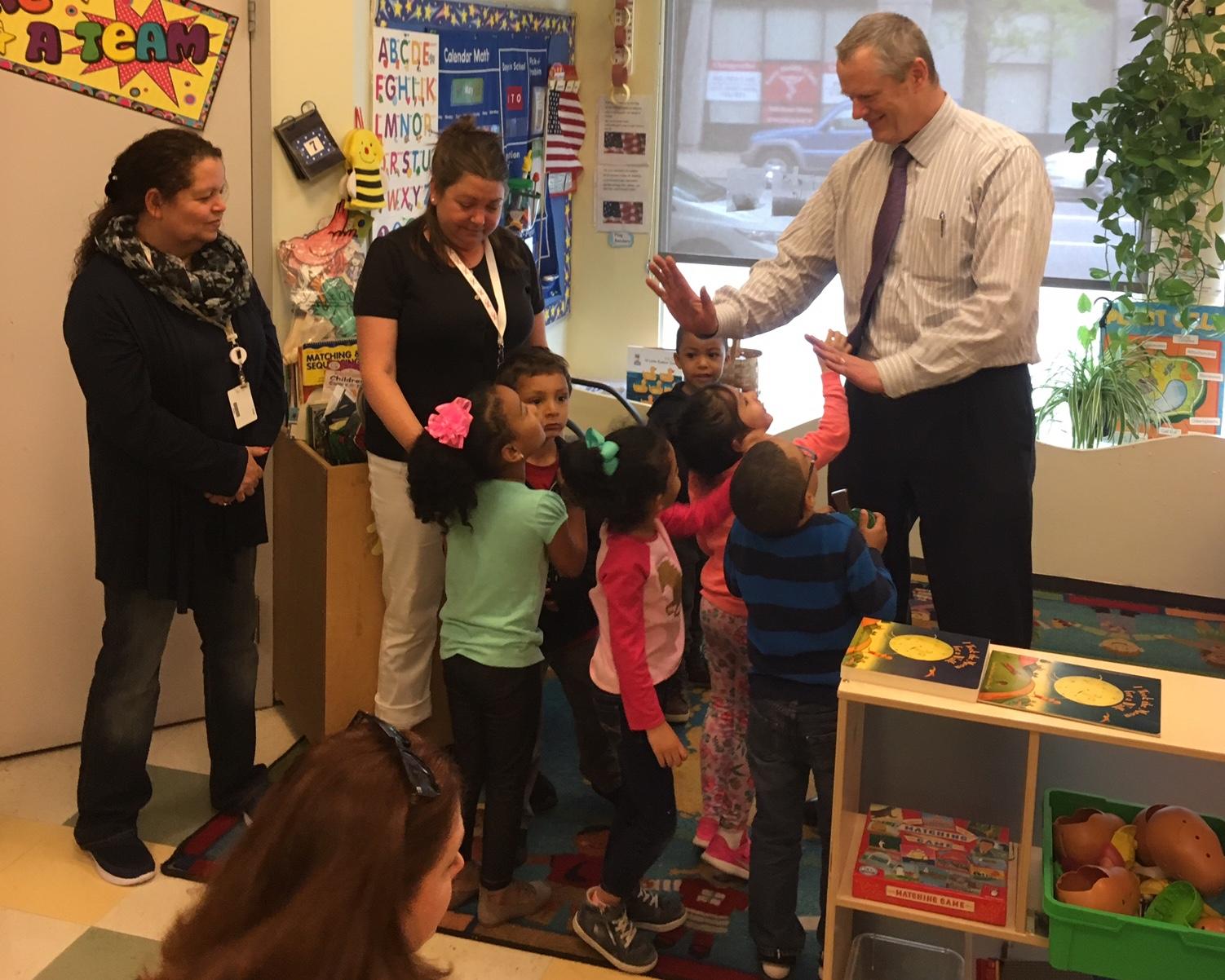 Photo of Governor Baker greeting children in a preschool classroom.