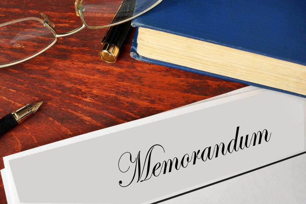 memorandum, pen and eye glasses on desk