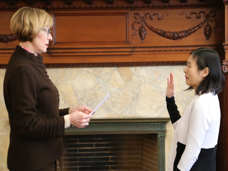 Auditor Bump, at left, swears in Dr. Kimberly Truong, right, as a member of the Self Determination Advisory Board at the State House