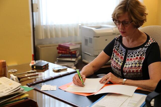 Auditor Bump writing a letter at her desk.