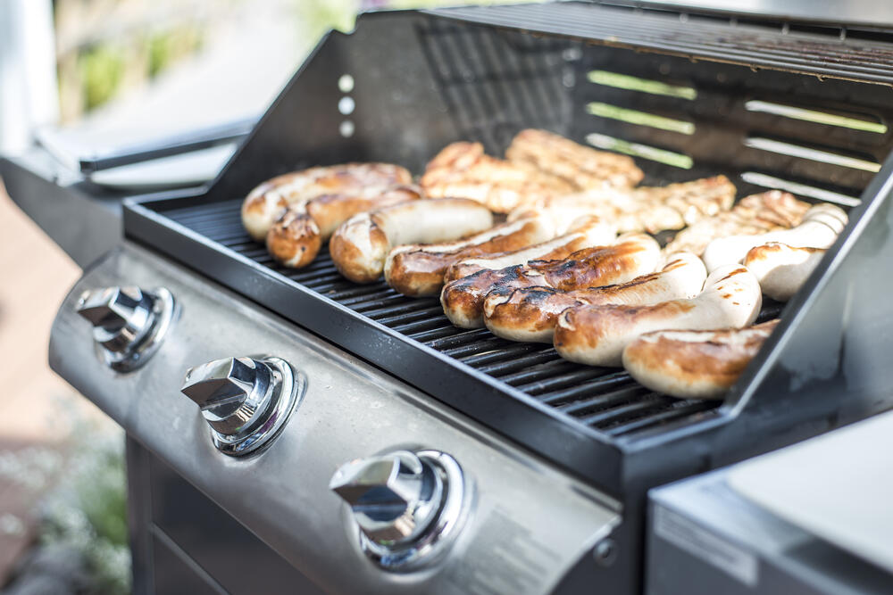 Photo of chicken cooking on a gas grill