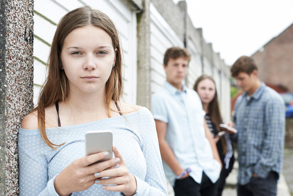 Shutterstock image of a teenager with a cell phone.