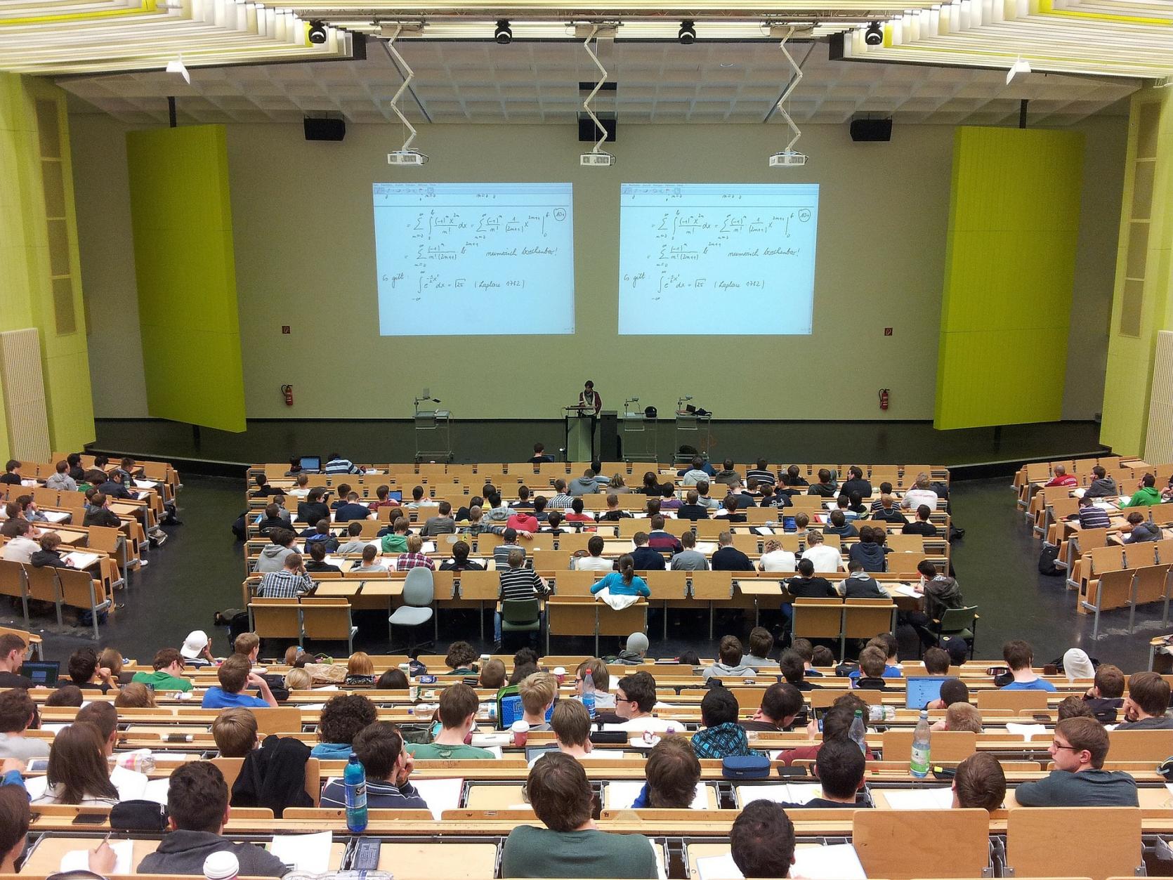 View from the back of a lecture hall full of students.