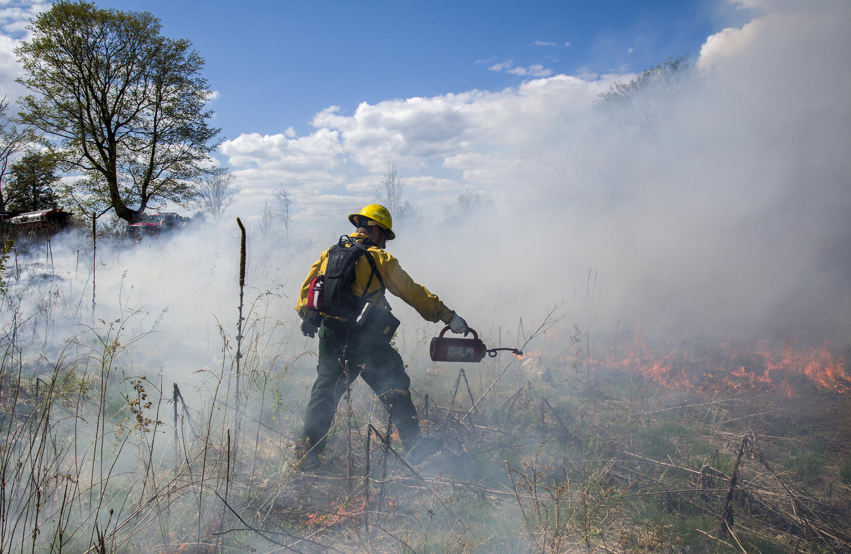 A prescribed burn crew member igniting a burn unit.