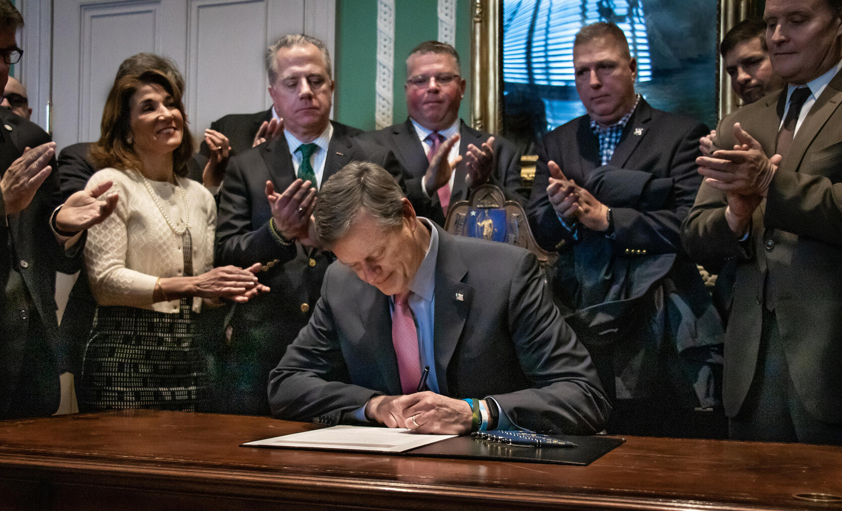 Governor Baker signs legislation surrounded by members of the first responder community.