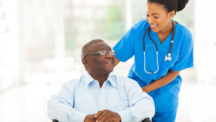 An image of a personal care attendant helping a patient. 