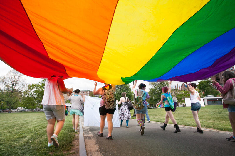 Group holding a large rainbow pride flag