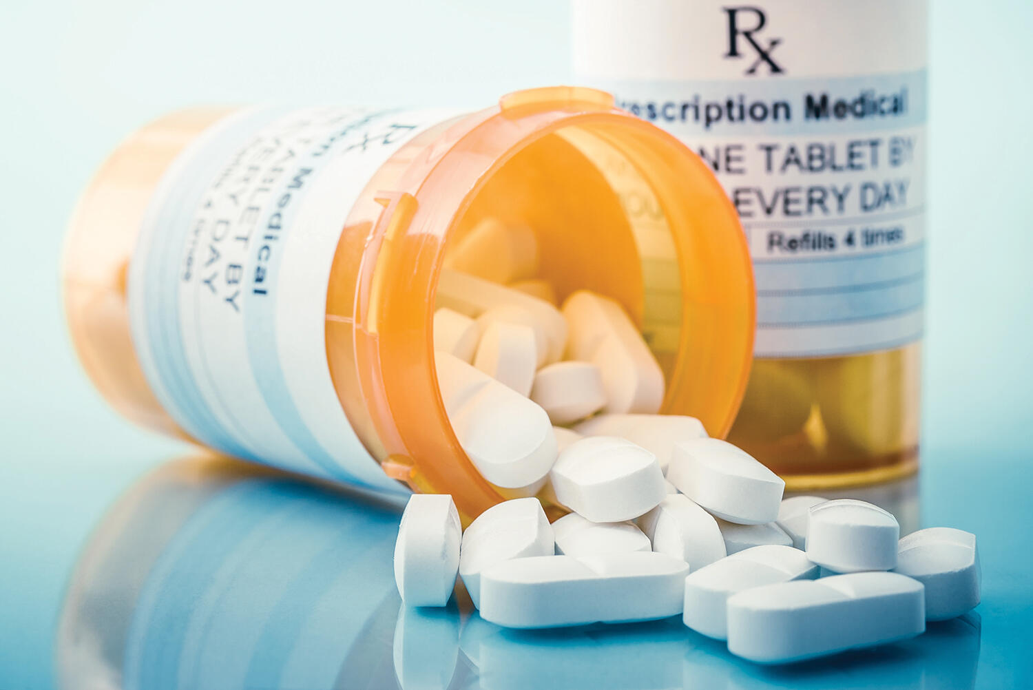 An image of a prescription pill container with pills spilling out.