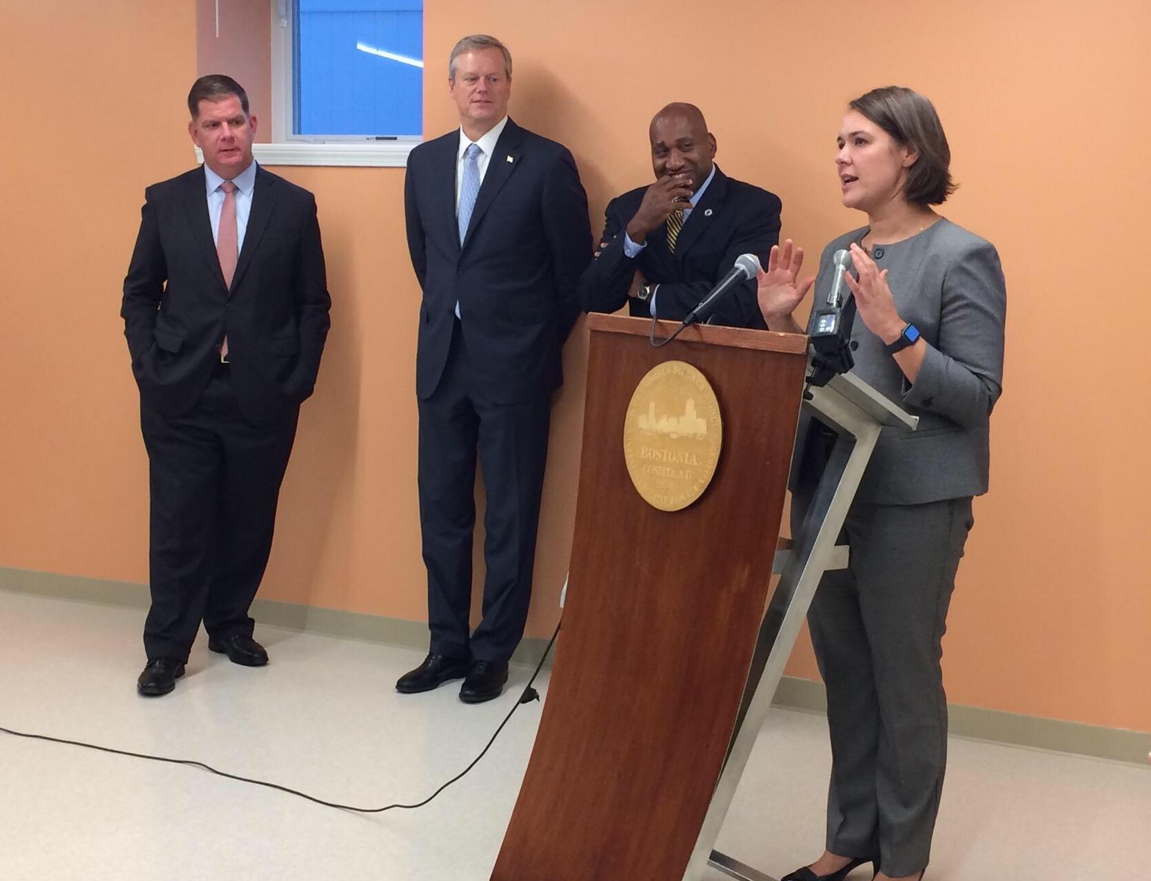 This is a photo of Governor Baker, Mayor Walsh, Representative Holmes, and Commissioner Aigner-Treworgy speaking at an event.