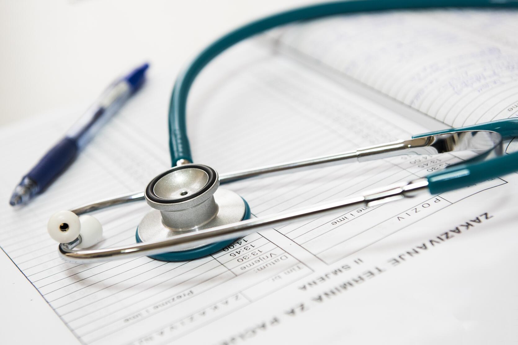 An image of a stethoscope and a pen from a doctors office 