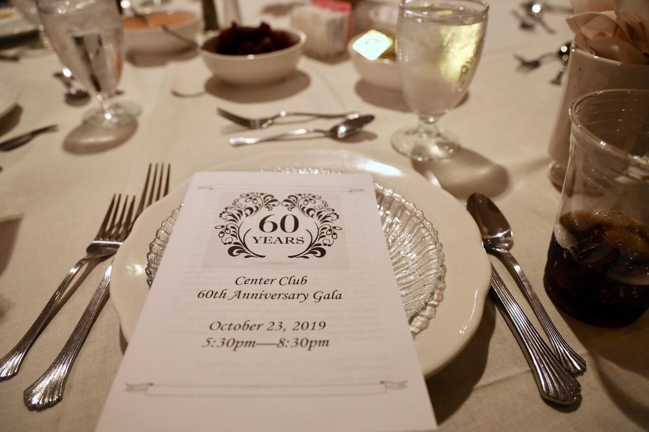 Printed event program placed on the dinner plate on a table