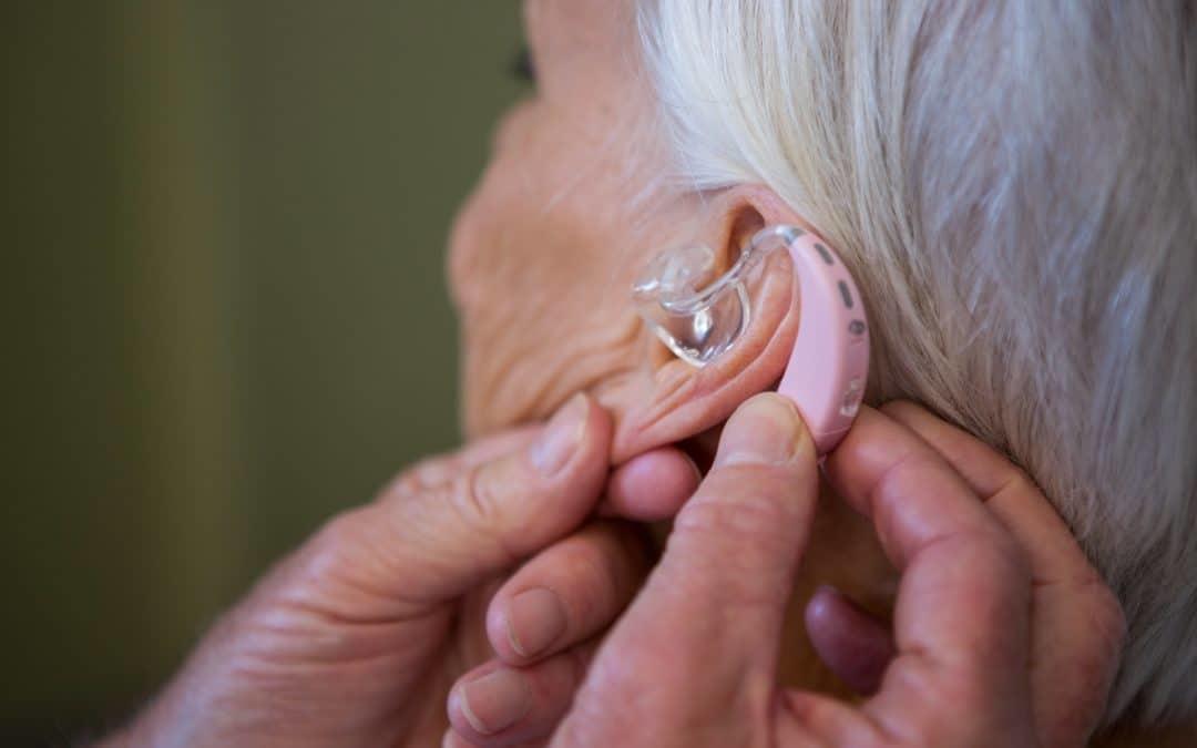 An image of an elderly woman with a hearing aid.