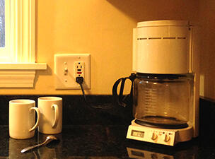 Electric coffee maker on kitchen counter near wall outlet
