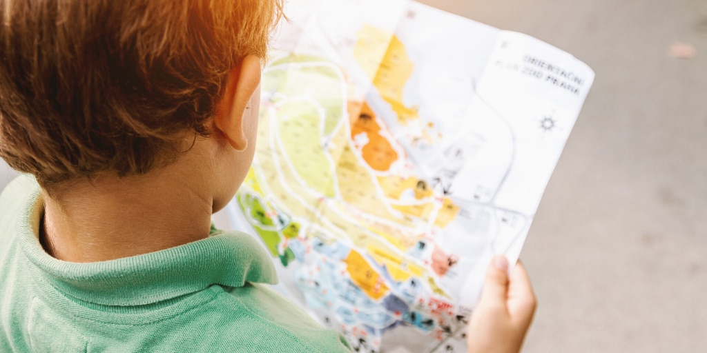 An image of a young child reading a map. 