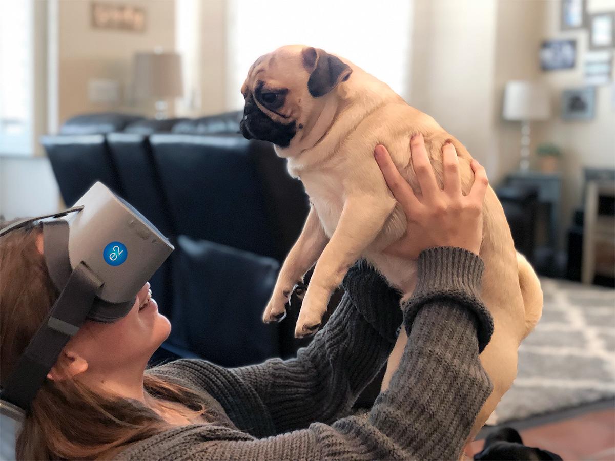 Girl wearing NuEyes e2 Wearable Magnifier while holding a small dog up close