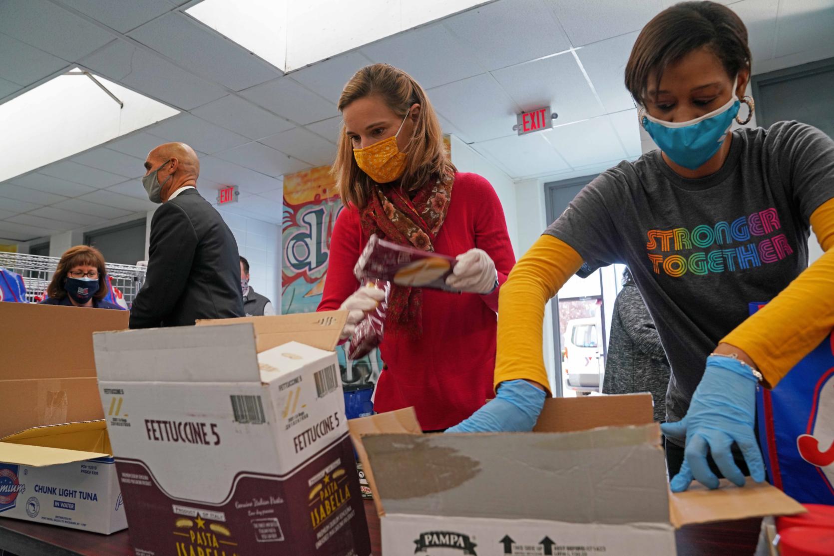 Energy and Environmental Affairs Secretary Kathleen Theoharides helps assemble food donation bags at the Melnea A. Cass Recreational Complex in Boston on Tuesday. 