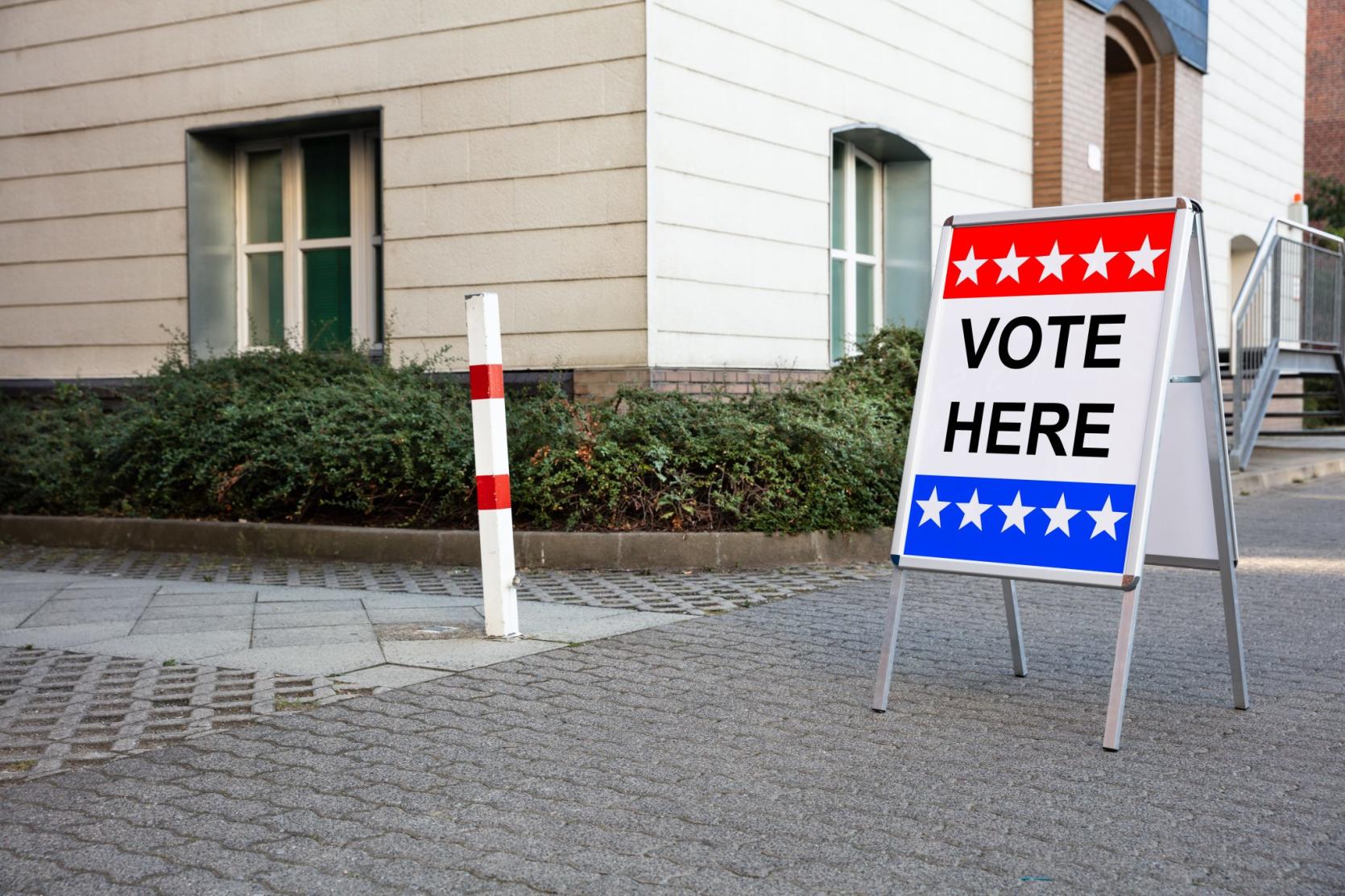 An image of a sign that says vote here.