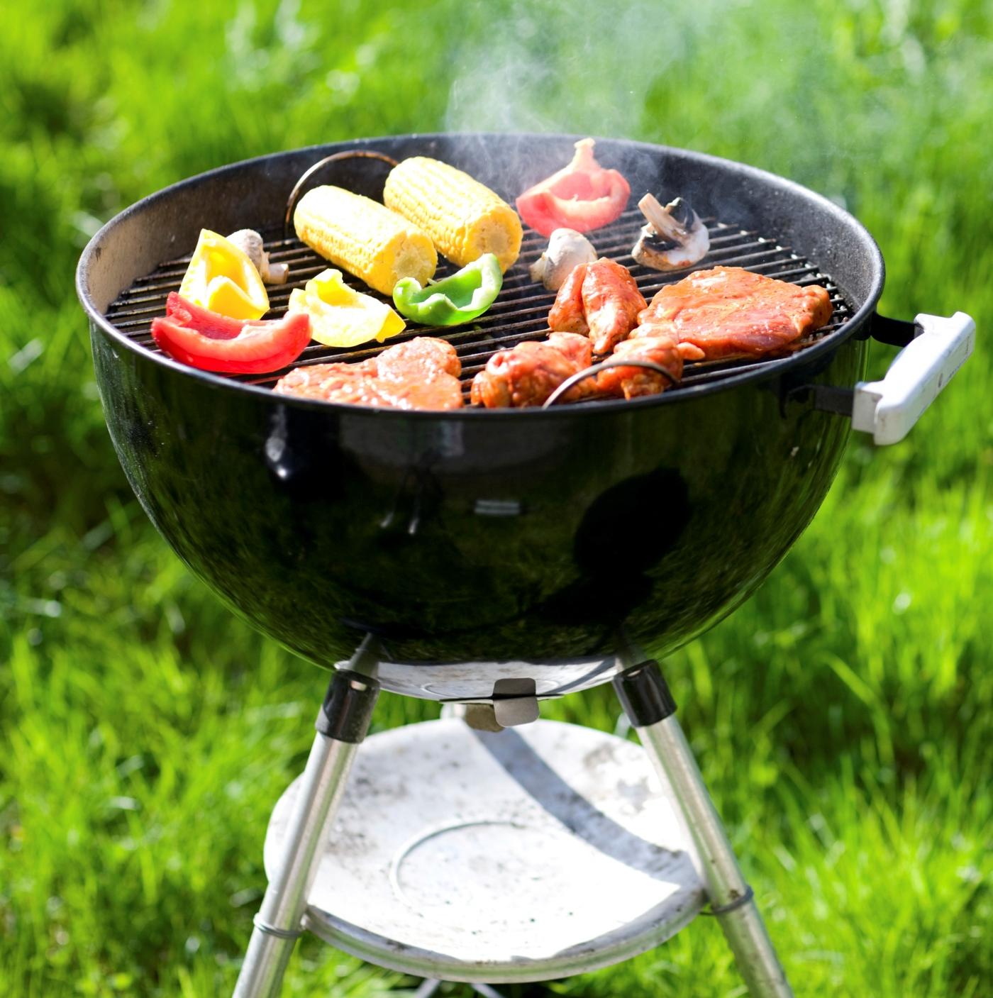 Charcoal grill with colorful food on it