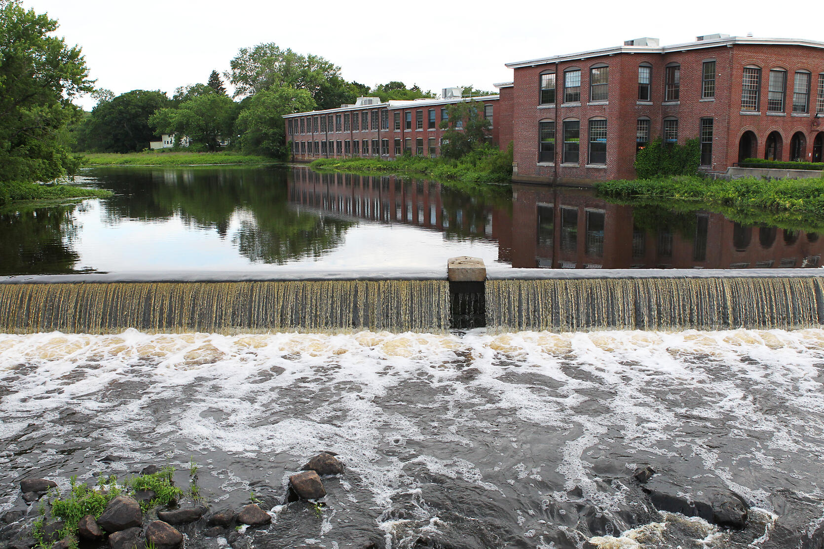 Water spilling over a small dam.