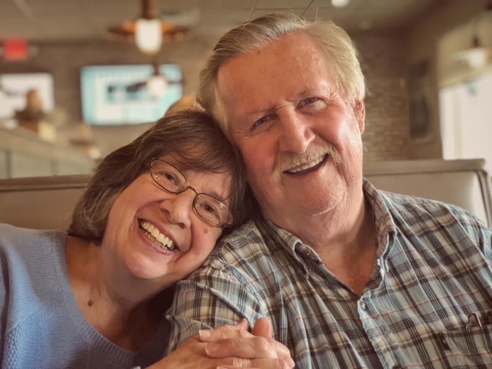 MCB Children's Services Worker Linda Geary and husband Terry smile together while sitting in a restaurant booth