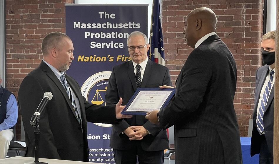 Mr. Frank Oglesby, Margaret Oglesby's husband, presents Worcester District Probation Officer Paul Prentiss the Margaret Elizabeth Oglesby Award as Probation Commissioner Edward Dolan looks on.