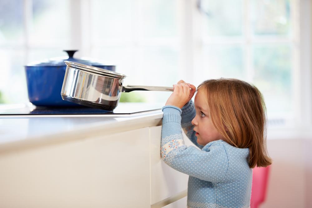 Child reaching for a pot on the stove