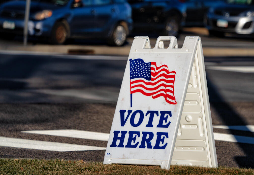 Photo shows a vote here sandwich board sign outside a polling location.