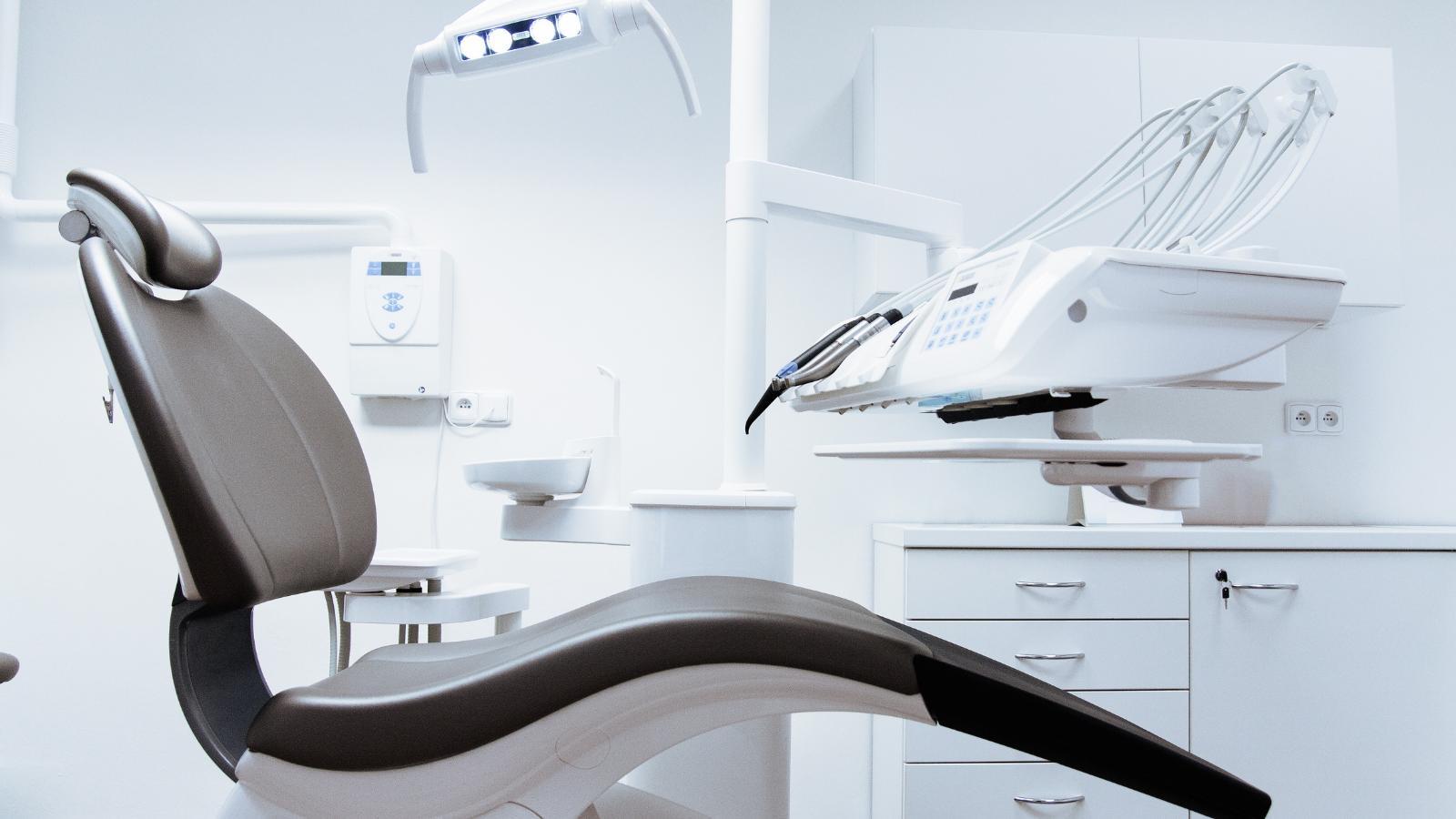 Interior of dentist office with chair, light, and table.