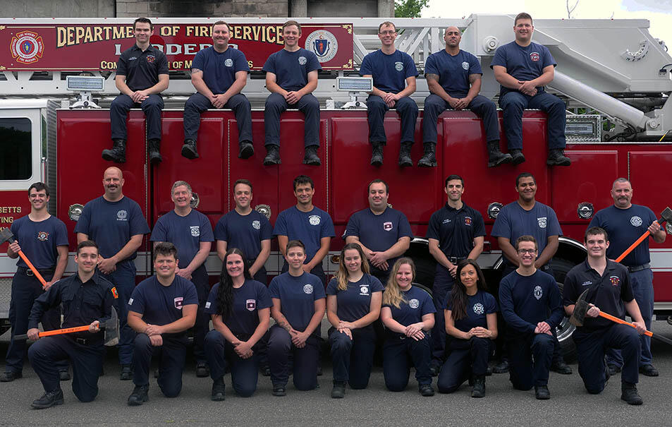 Picture of 25 firefighters on and around a ladder truck