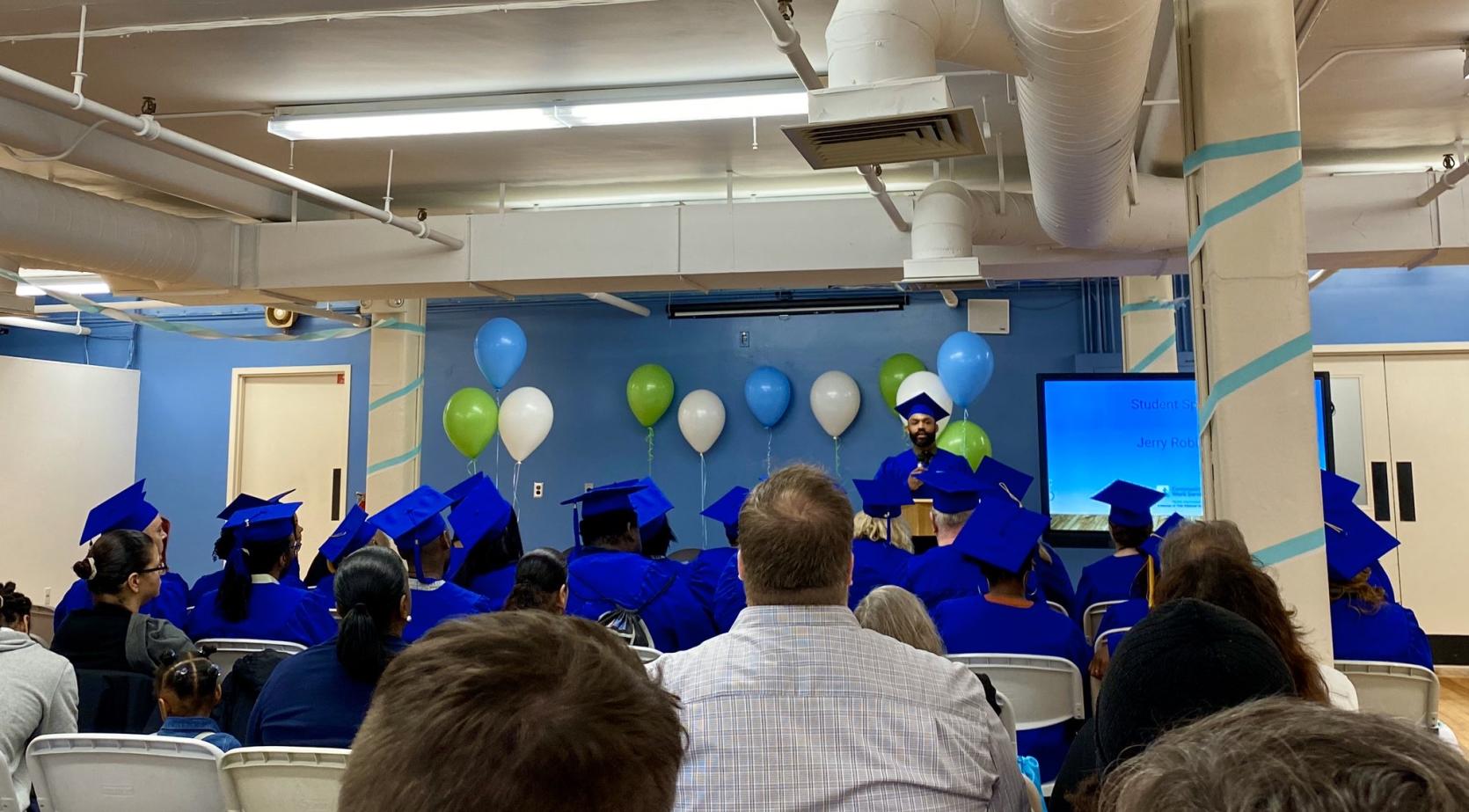 Commencement speaker addresses their fellow graduates at a commencement ceremony for the Community Work Services Re-Entry Workforce Development Demonstration Program.