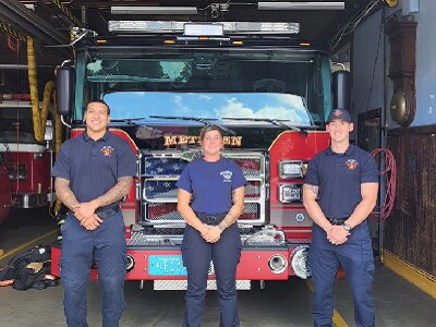 Three firefighters in front of truck