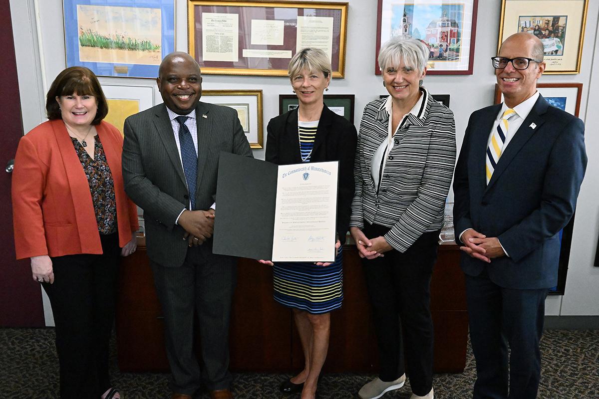 MRC Commissioner stands next to four other leaders in the Commonwealth as they pose with the proclamation from the Governor