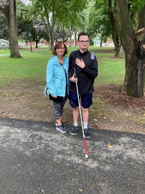 A photo of MCB COMS Grace Cummings and MCB intern Tom Geraci with his white cane