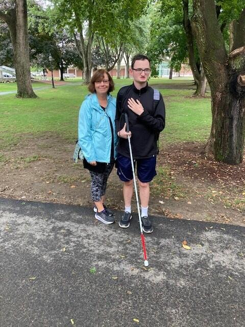 A photo of MCB COMS Grace Cummings and MCB intern Tom Geraci with his white cane