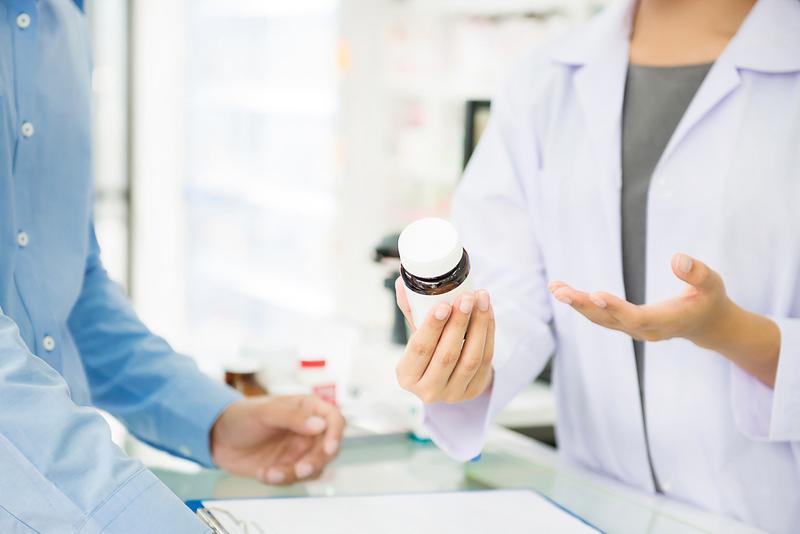Photo of pharmacist explaining medication bottle