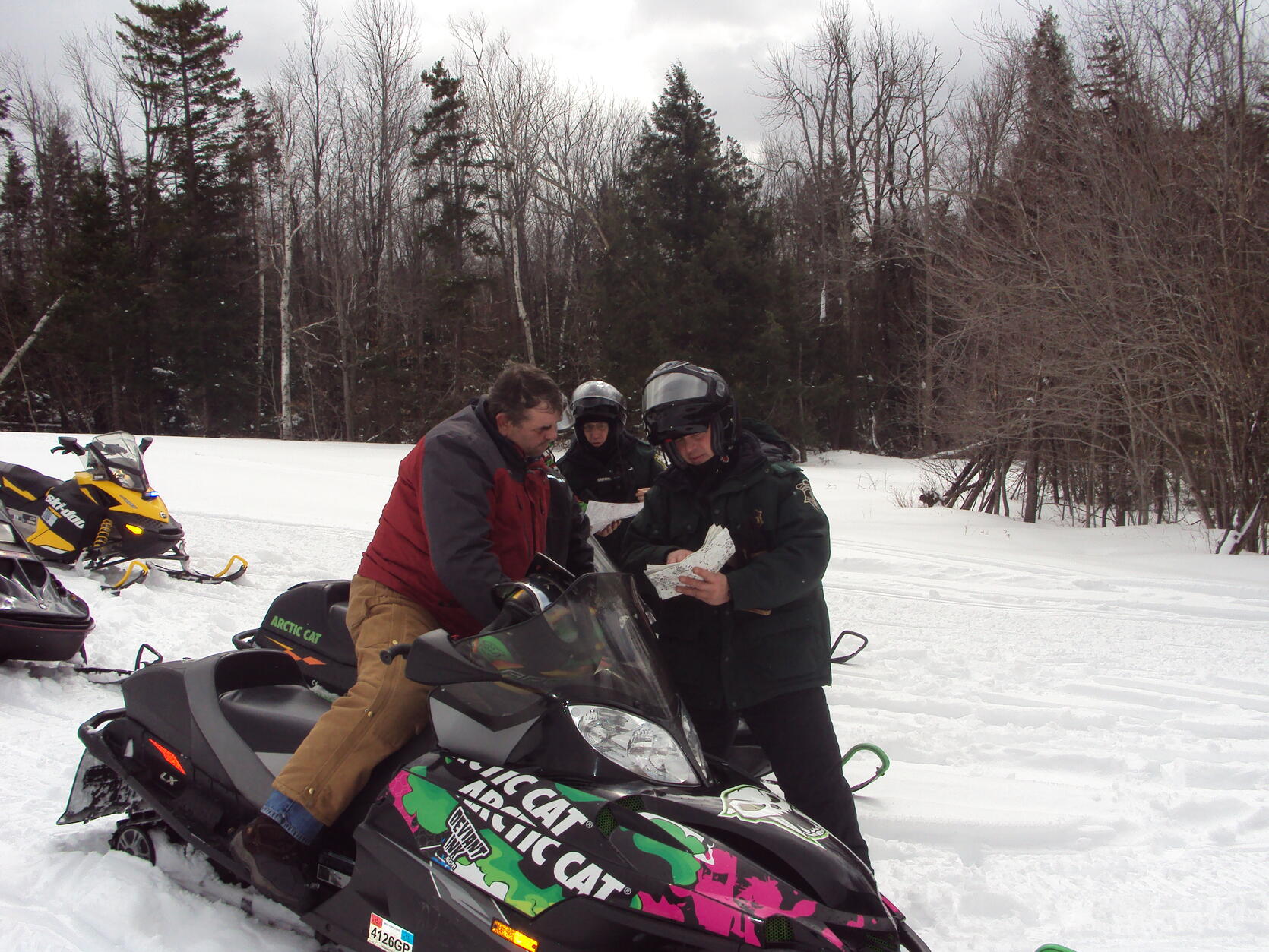 Environmental Police Officer next to snowmobile