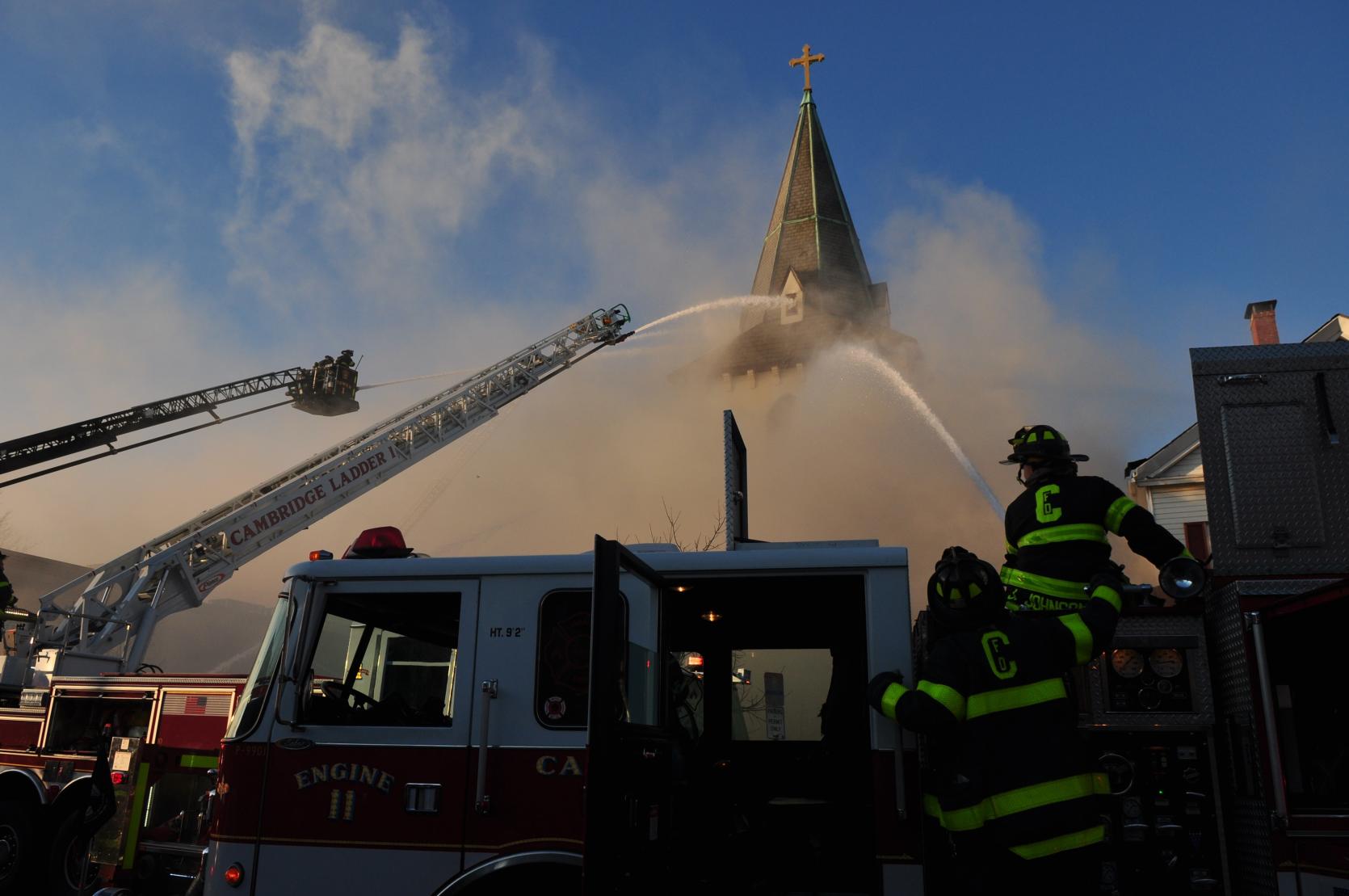 A photograph of many fire engines spraying water on a burning church